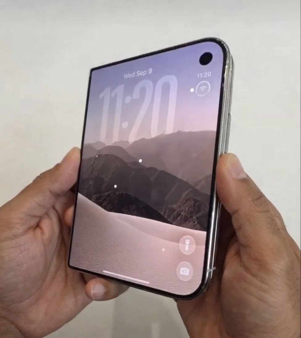 The iPhone Duo closed, showing the narrow 5.4 inch cover screen with a punch hole camera in the top right corner